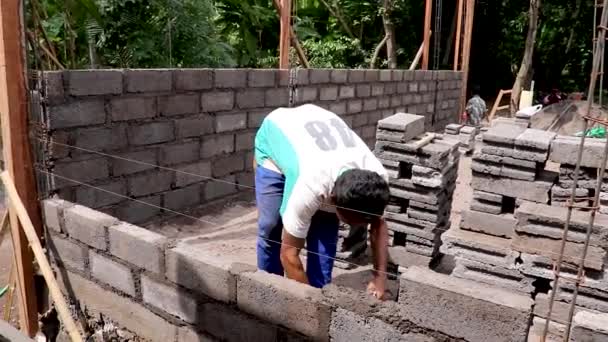 Tiro de perto nas mãos dos pedreiros, o construtor coloca os tijolos, usando uma corda esticada para um nível uniforme de materiais de alvenaria — Vídeo de Stock