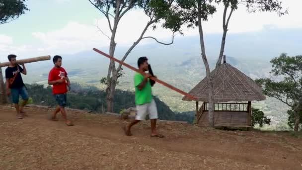 Homem carregando uma árvore de bambu usada como recurso de energia sustentável renovável e diferentes tipos de produtos ecológicos — Vídeo de Stock