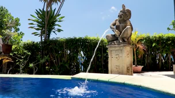 Balinese Hindu statue fountain by a swimming pool — Stock Video