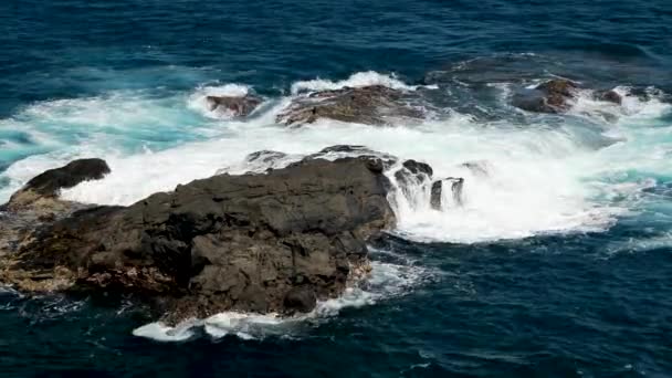 Kinematografické azurové, modré, zelené, tyrkysové vlny narážející na malebné černé sopečné útesy a ostré skály. Letecký dron letící nad bouřlivými tichomořskými vodami, Havaj Maui USA. Vzdušné zázemí oceánu — Stock video