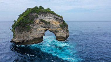 Fil Kayası oluşumu. Bu doğal kaya kemeri Hint Okyanusu 'nda, Bali' nin Nusa Penida Adası 'nda bulunur. Uçurumun kenarındaki bu büyük açık delik dalgalar tarafından oluşmuştur.