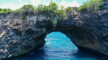 Nusa Penida 'daki muhteşem Broken Beach Pasih Uug' un hava manzarası. Arka planda doğal kemer, köprü ve deniz havuzu var. Bali, Endonezya. Hasselblad 'da gün doğumunda vuruldu..