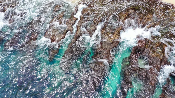 ターコイズブルーの水の美しい岩 波が海岸の石の上を転がり — ストック写真