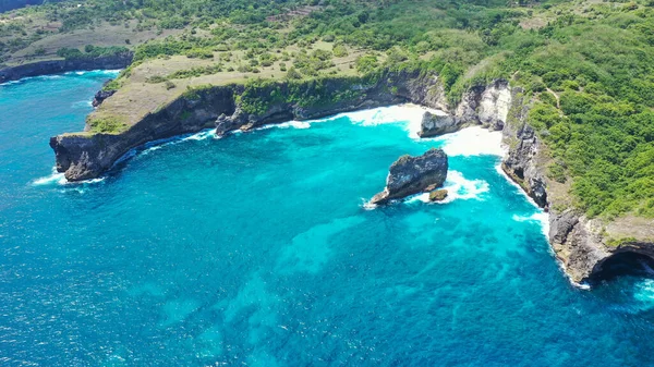 空中无人驾驶飞机沿着悬崖飞行 而汹涌的蓝色热带海洋的海浪冲向了悬崖 — 图库照片