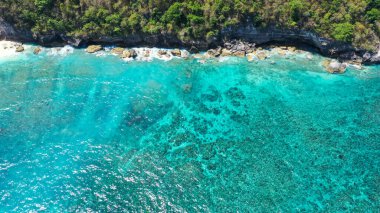 Tropik sahil manzarası, deniz taşları ve turkuaz okyanus, mavi gökyüzü. Atuh plajı, Nusa Penida adası, Endonezya 'nın Bali adasının güneydoğusunda yer alır. Seyahat konsepti. Endonezya