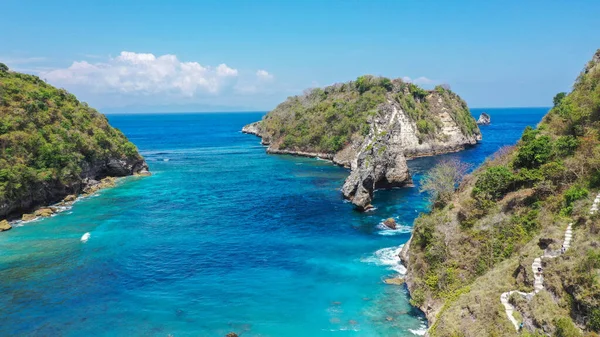 Vista de la playa tropical, rocas marinas y el océano turquesa, cielo azul. La playa de Atuh, la isla de Nusa Penida, se encuentra al sureste de la isla de Bali, Indonesia. Concepto de viaje. Países Bajos — Foto de Stock