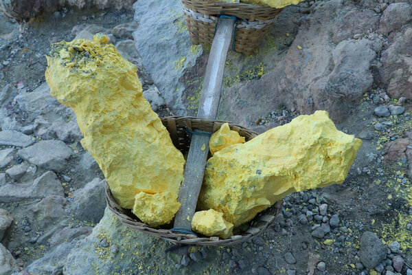yellow sulfur inside woven bamboo basket at volcanic crater Kawah Ijen