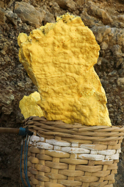 yellow sulfur inside woven bamboo basket at volcanic crater Kawah Ijen