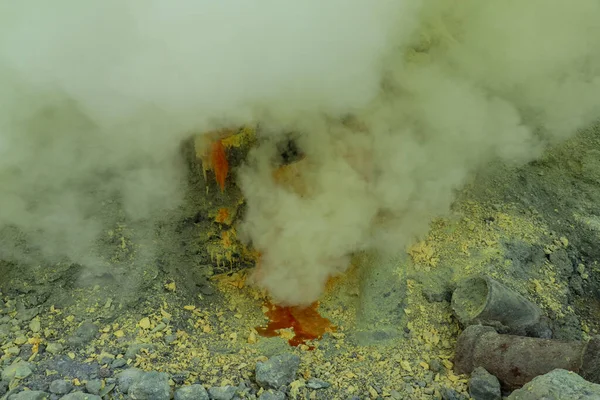 Kawah Ijen vulkanische krater meer en giftige zwavel rookgas, arbeiders halen zwavel uit dit rokerige gebied en dragen een-80-90 Kg.-mand vol zwavel op hun schouder en lossen de manden 3,5 km afstand — Stockfoto