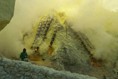 KAWAH IJEN VOLCANO, EAST JAVA, INDONESIA, 2 June, 2021. Sulfur miner collecting sulfur inside the crater of Kawah Ijen volcano in East Java, Indonesia
