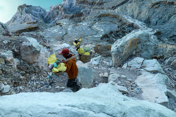 Kawah Ijen, East Java, Indonesia, 2 June, 2021. Sulfur miner hiking down into the crater of Kawah Ijen volcano in East Java, Indonesia