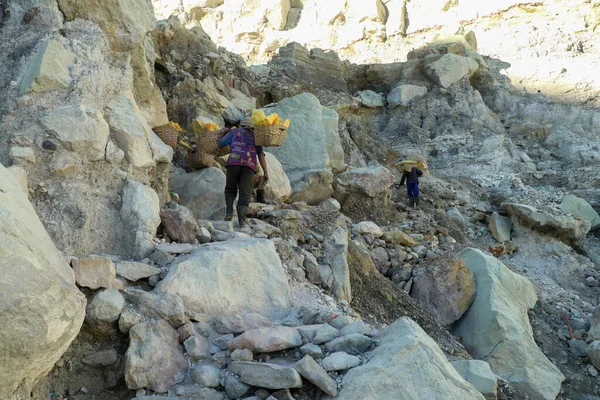 Kawah Ijen, Indonesia, 2 June, 2021. Worker carries sulfur inside Ijen crater in Ijen Volcano, Indonesia. He carries the load of around 60kg to the top of the rip and then 3km down — Foto Stock