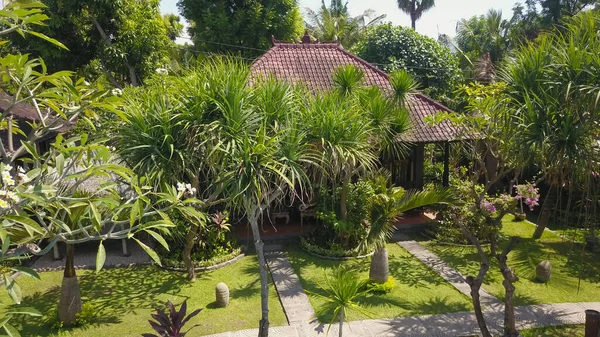 Harmonischer balinesischer Garten. Zen-Konzept. Holzlounge versteckt in Bäumen und Laub, Bali, Indonesien — Stockfoto