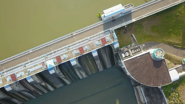 インドネシアのジャワ島のBendungan Sampean Baru上空の空中トップダウンドローン。コンクリート構造の水力発電生態再生可能エネルギーの上のアスファルト道路橋でダム貯水池の上に撮影 — ストック写真