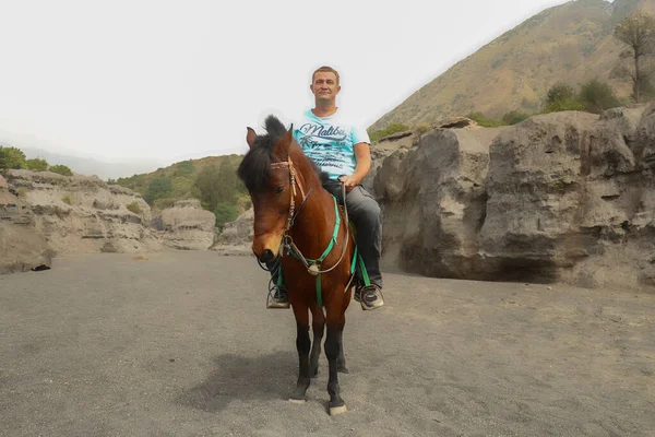 Mt.Bromo, Pasuruan, East Java, Indonesia - 28 May 2022. Человек на лошадях прогулка возле индуистского храма Пура Лухур Poten расположен у подножия вулкана Бромо, Бромо Тенггер Семеру Национальный парк — стоковое фото