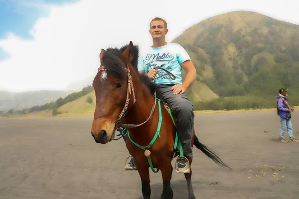 Mt.Bromo, Pasuruan, East Java, Indonesia - 28 May 2022. Мужчина ездит на коричневой лошади в районе горного бромо, Индонезия — стоковое фото