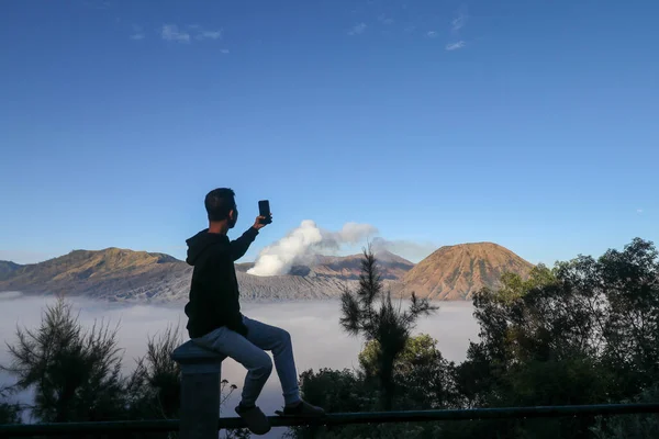 Pemuda asia mengambil gambar pemandangan pegunungan yang indah di Taman Nasional Gunung Bromo, Jawa Timur, Indonesia — Stok Foto