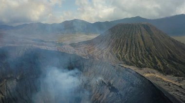 Yukarıdan bakıldığında, kraterden yükselen gaz bulutlarıyla Bromo Dağı 'nın çarpıcı hava manzarası. Bromo Dağı Doğu Java, Endonezya 'da aktif bir volkandır.