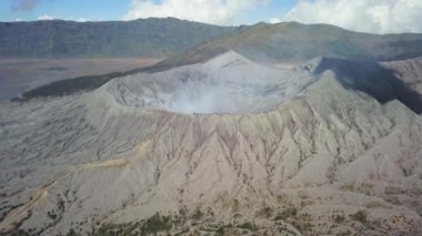 Bromo Dağı 'nın dumanlı görüntüsü, ufuk açısı, Batok kraterine doğru ilerliyor, Bromo' nun yan taraflarını gösteriyor. Java, Endonezya