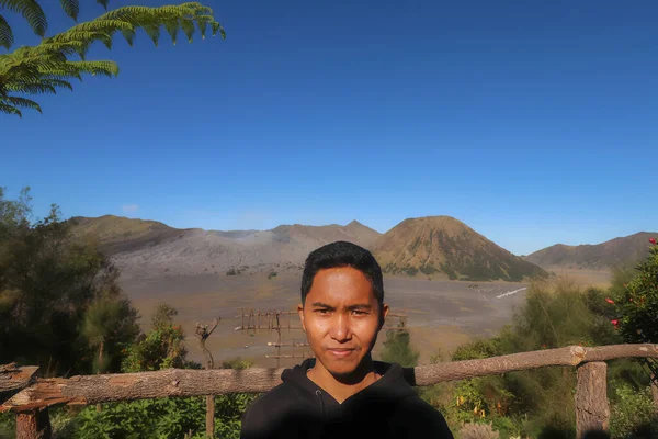 Asian men posing on mount bromo against a bright blue sky background — Stock Photo, Image