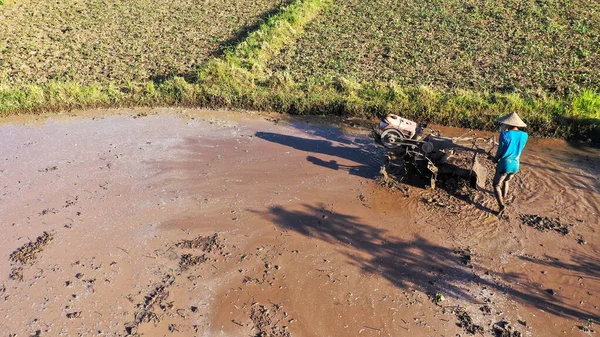 Lantbrukare plöjning lerigt fält med handtraktor på indonesien, Asien — Stockfoto