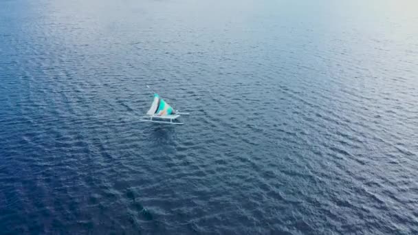 Kleurrijke krab klauw zeil op witte houten Jukung bootje bij de kust van Bali — Stockvideo