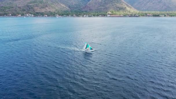 Kleurrijke krab klauw zeil op witte houten Jukung bootje bij de kust van Bali — Stockvideo