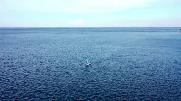 インドネシア、バリ島のアメッドにあるジェムルーク湾とビーチを航海する伝統的なユクン漁船の素晴らしい空中ドローン映像 — ストック動画