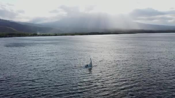 Ohromující letecké drone záběry tradiční Jukung rybářský člun plachtění moře s dramatickými slunečními paprsky v pozadí. Amed in Bali, Indonesia — Stock video