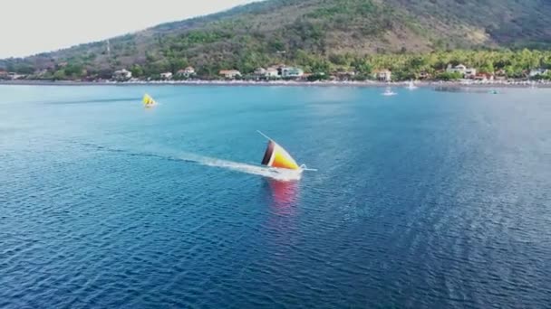 Légi drón oldal nyomkövető gyors vitorlázás hagyományos halászhajó. Szélmeghajtású jukung feszes vitorlával — Stock videók
