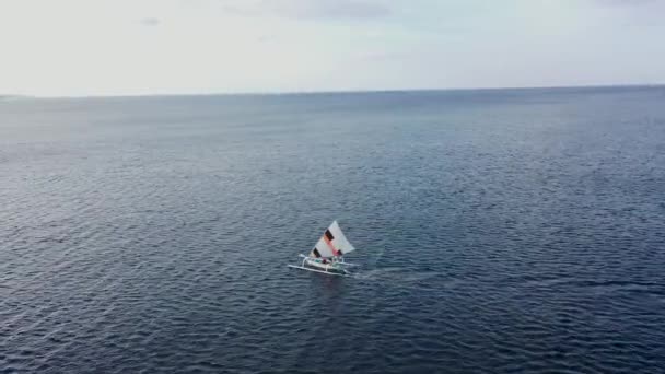 Letecký dron straně sledování rychle plachtění tradiční rybářské lodi. Vítr poháněný jukung s napnutou plachtou — Stock video