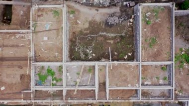 Yeşil bölgede yeni bir binanın havadan aşağı görüntüsü. İnşaat alanının üzerinden uçuş. Emlak binası. Apartman yapım aşamasında. Yeni geliştirme sitesi