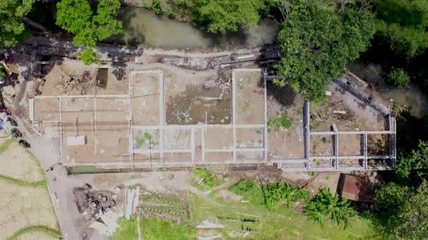 Luchtdrone verplaatst zich naar bouwplaats in groen gebied. Bouw betonnen fundering voor een nieuw huis aan de rivier — Stockvideo