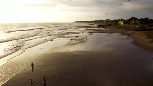 Drohnenschuss über dem Echo Beach während des Sonnenuntergangs in Canggu, Bali. Meeresküste bei Sonnenuntergang. Luftaufnahme des Sonnenuntergangs an der Meeresküste, Meer, Strand, Himmel, Wolken. Bali, Indonesien. Sonnenuntergang auf der Insel Bali. 4K — Stockvideo