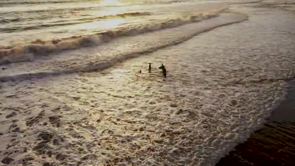 Luftaufnahme eines Strandes mit im Wasser spielenden Kindern bei Sonnenuntergang. In der Dominikanischen Republik. Kinder spielen im Sand am Strand am Meer bei Sonnenuntergang im Sommer. Schöne Hintergrundbeleuchtung — Stockvideo