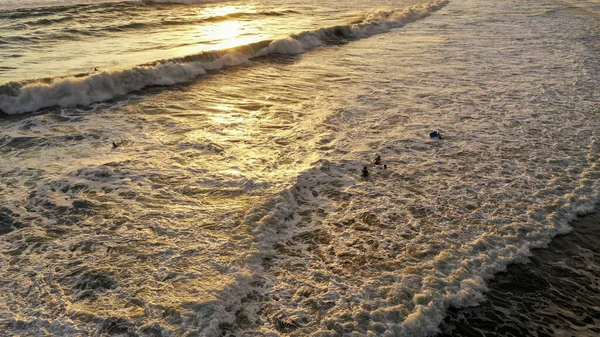 Повітряний вид пляжу з дітьми, що бавляться у воді після заходу сонця. У Домініканській Республіці. Діти бавляться на піску на березі моря на заході сонця влітку. Чудове заднє світло — стокове фото