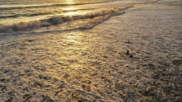 Luchtfoto van een strand met kinderen die bij zonsondergang in het water spelen. In de Dominicaanse Republiek. Kinderen spelen in het zand op het strand aan zee bij zonsondergang in de zomer. Mooie achtergrondverlichting — Stockfoto