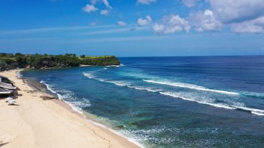 Arka planda geleneksel balıkçı teknesi olan tropikal kumsal deniz suyu ve güzel mavi gökyüzü. 4K