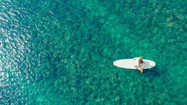 Les surfeurs attendent les vagues dans une eau claire près de la plage pittoresque, vue sur les drones. De haut en bas. Copiez l'espace pour votre texte — Photo