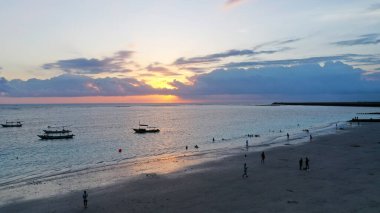 Okyanus dalgaları üzerinde gün batımı kum plajlarını yıkar. Dağ siluetinin üzerinde hava güneşi batıyor. Tropik hiç kimse doğa deniz manzarası. Cennet adası El Nido, Filipinler, Asya deniz koyunda. Sinematik İHA çekimi