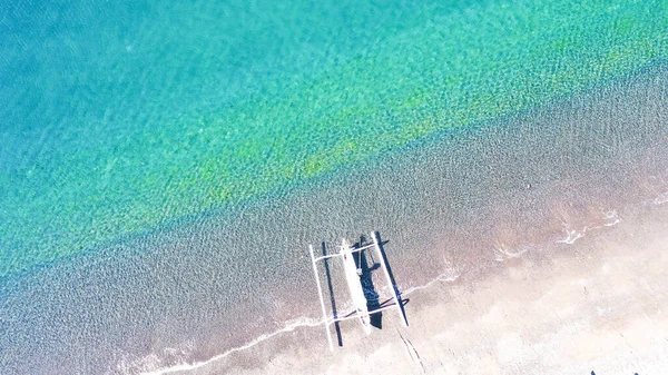 Veduta aerea dall'alto verso il basso della tradizionale barca in legno sulla spiaggia vulcanica di sabbia nera di Amed, Bali, Indonesia. Barche da pesca tradizionali chiamate jukung sulla spiaggia di sabbia nera — Foto Stock