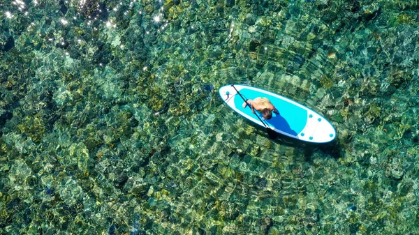 ハワイ立っている paddleboard 青い水の上で幸せにパドル板女性 paddleboarding します。若い混血白人女性アジアモデルの夏にハワイのビーチでの休日の休暇旅行 — ストック写真
