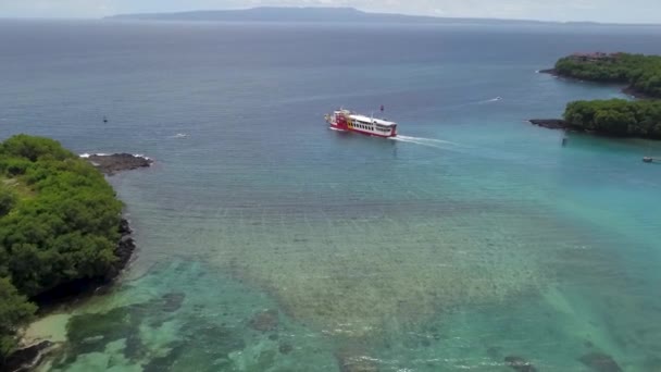Aerial drone footage of a roro ferry that leaves the Padang Bai harbor in Bali to cross the sea toward Nusa Penida in Indonesia — Stock Video