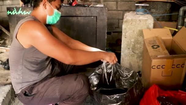 Muž položí mosaznou váhu na tradiční mechanickou litinovou stupnici, pak nalije barvicí prášek do sáčku ze skladovací nádoby, dokud pánev a odměrka nevyváží — Stock video