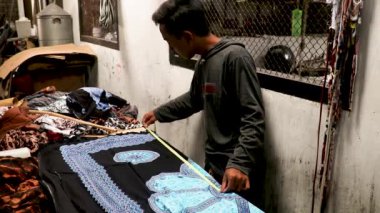 Kumaşı ölçen profesyonel moda tasarımcısı. Genç Asyalı adam iş yerinde yeni kıyafet koleksiyonu yapıyor.