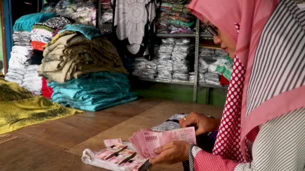 La mujer musulmana está contando billetes. Contando la rupia indonesia. Concepto de negocio contando dinero — Vídeos de Stock