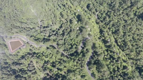 Vlieg over kronkelende weg, passeren weelderige begroeide tropische gebied, top-down luchtfoto van Kata Sai Yuan. Regenwoud bedekt heuvel helling, uitzicht van boven. Camera draai en volg de bocht van de rijbaan — Stockvideo