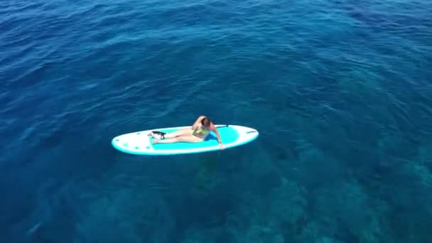 Luftaufnahme. Junge Frauen haben Spaß. Stand Up Paddling im Meer. SUP. Rotes Haar Mädchen Training auf Paddle Board — Stockvideo