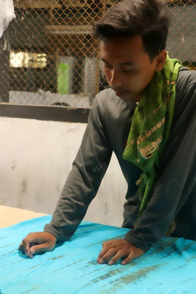 Asijské muž krejčí módní oblečení šaty návrhář pracující s látkou na stole — Stock fotografie