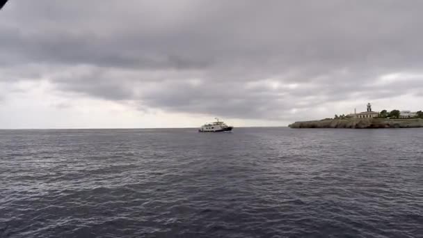 クルーズ船は曇りの日にメノルカ島のシウタデッラ港に到着します 港に入る船のクルーズ — ストック動画